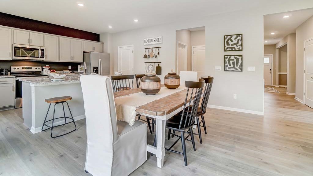 Dining room table and kitchen with views into the mudroom and the front foyer hallway.