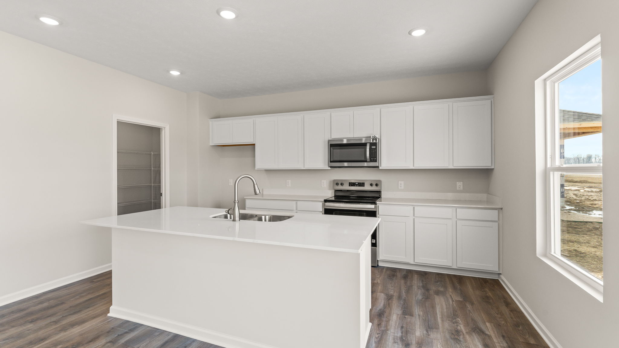 three-quarter view of kitchen with quartz countertops and white cabinetry