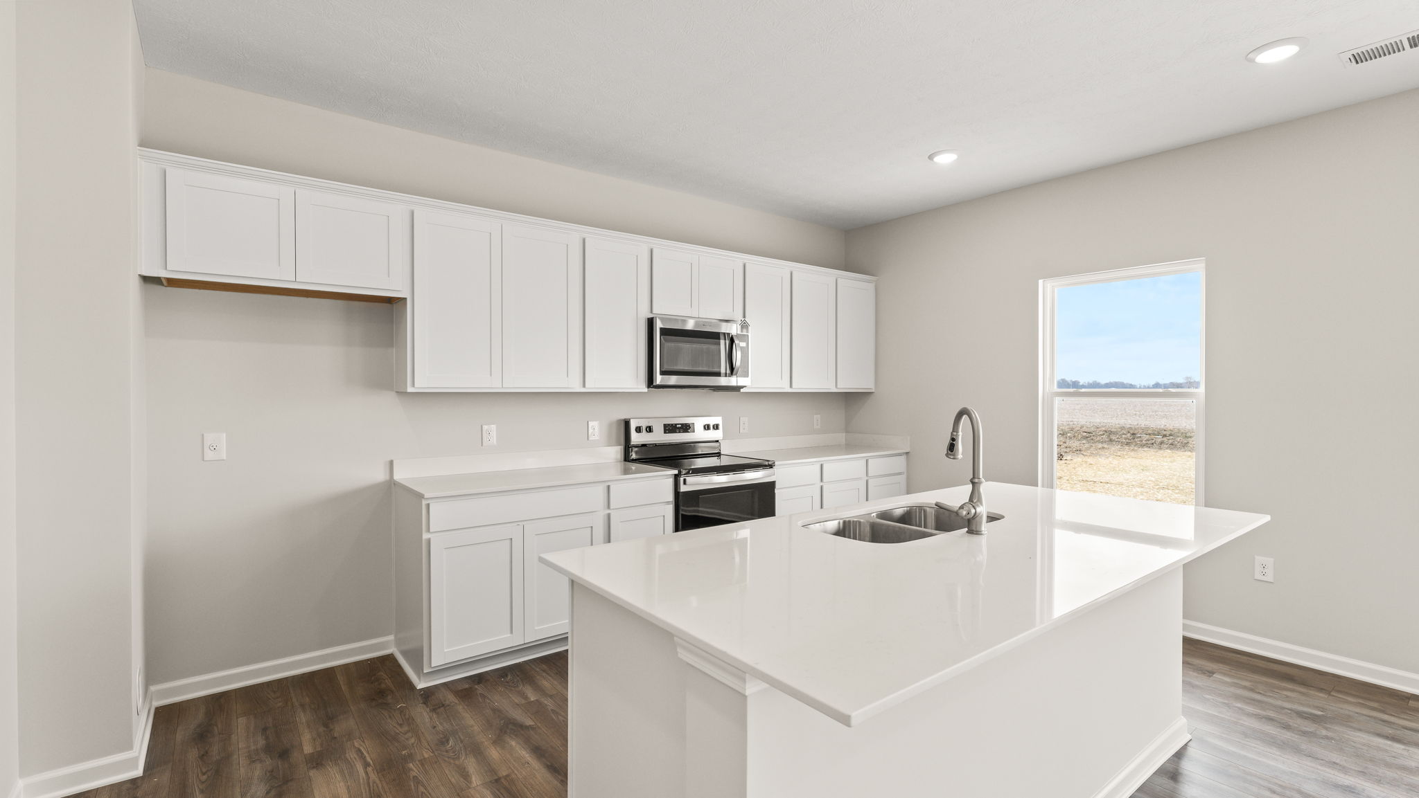 three-quarter view of kitchen with quartz countertops and white cabinetry