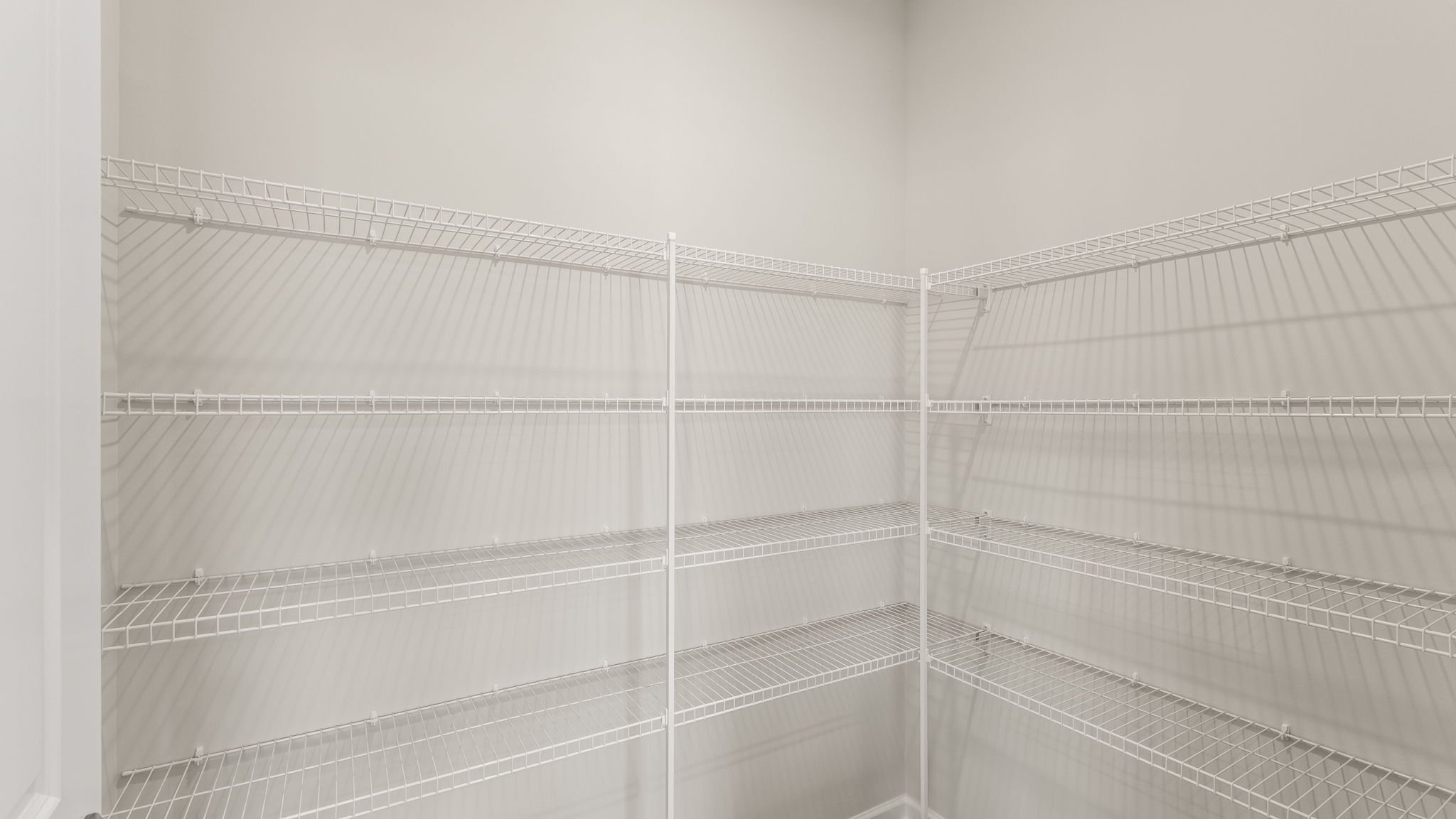 Walk-in pantry of kitchen with wire shelving.