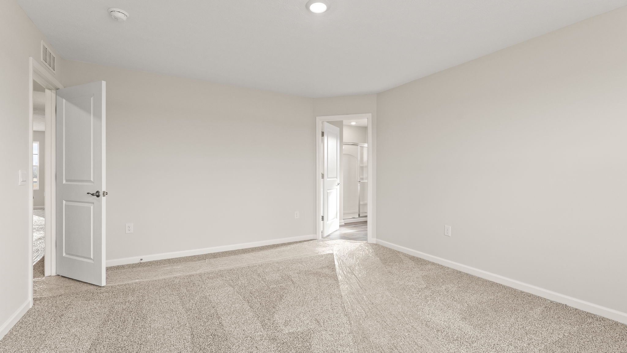 Primary bedroom with view of primary bathroom.