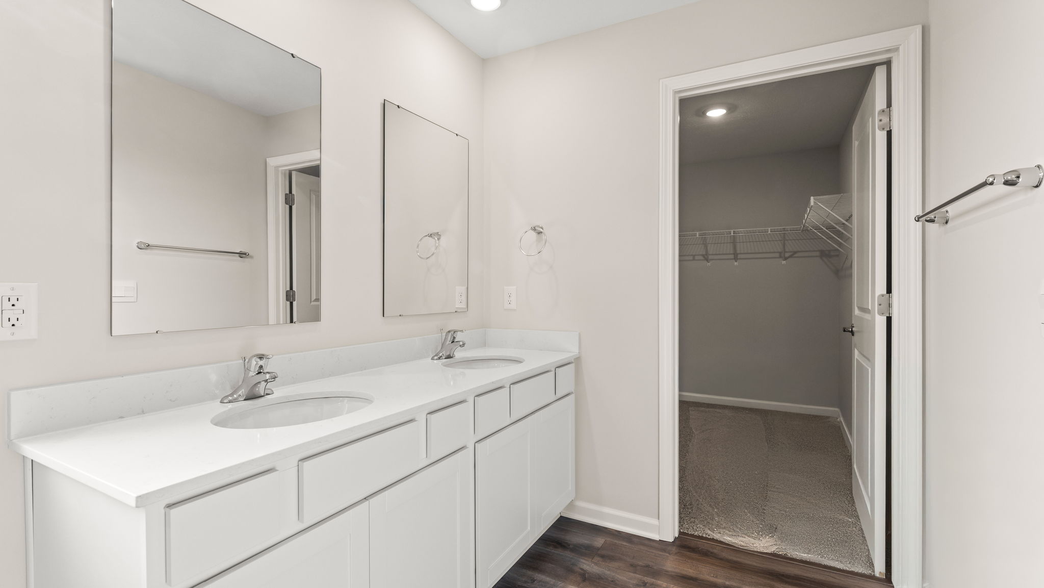 Primary bathroom with dual-mirror sink and closet.