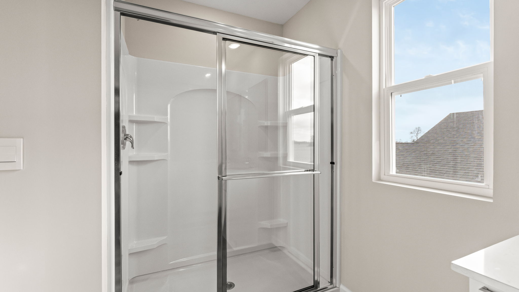 Closeup of walk-in shower with tiered shelving.
