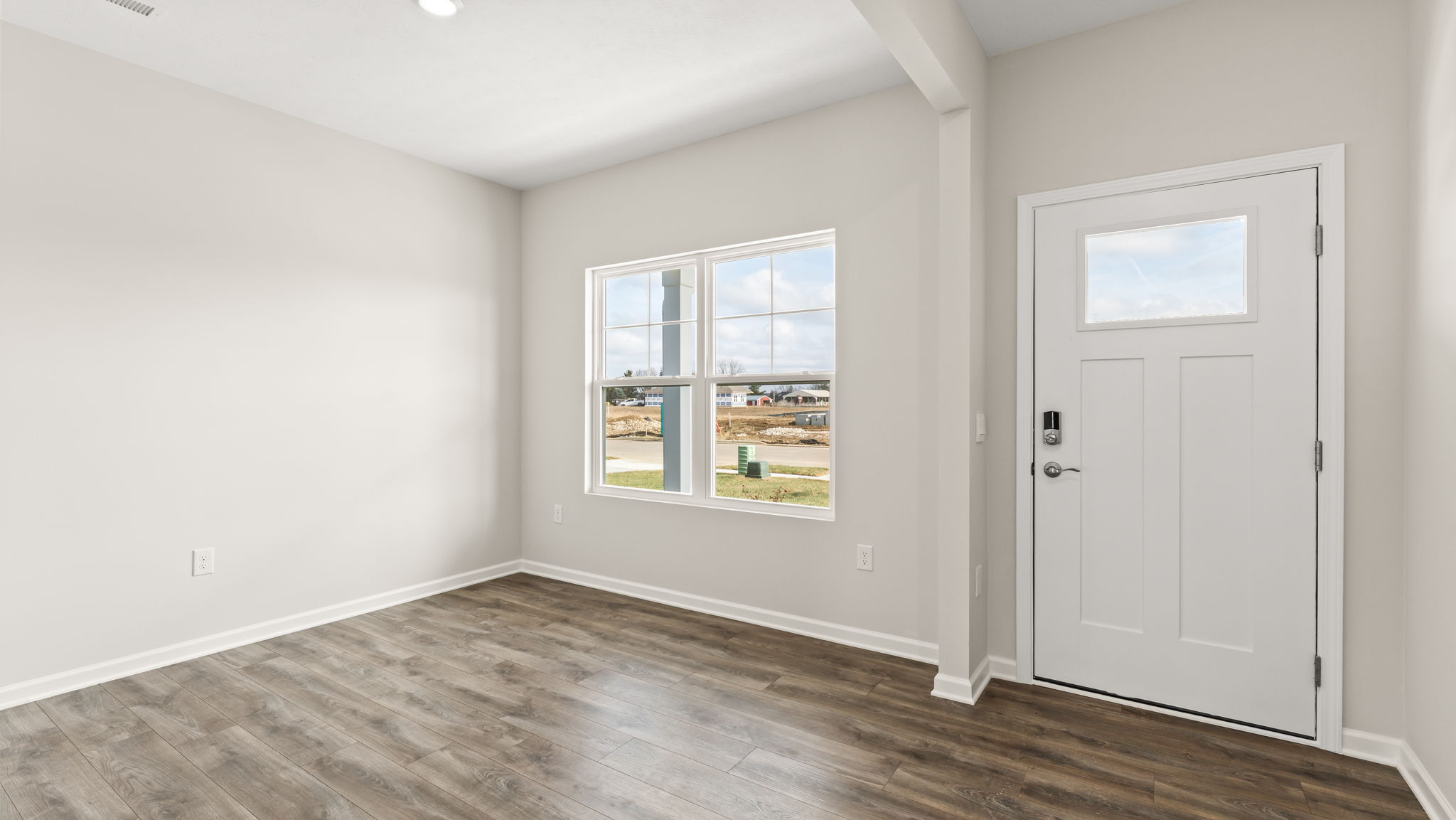 Front door and flex room with open area and windows.