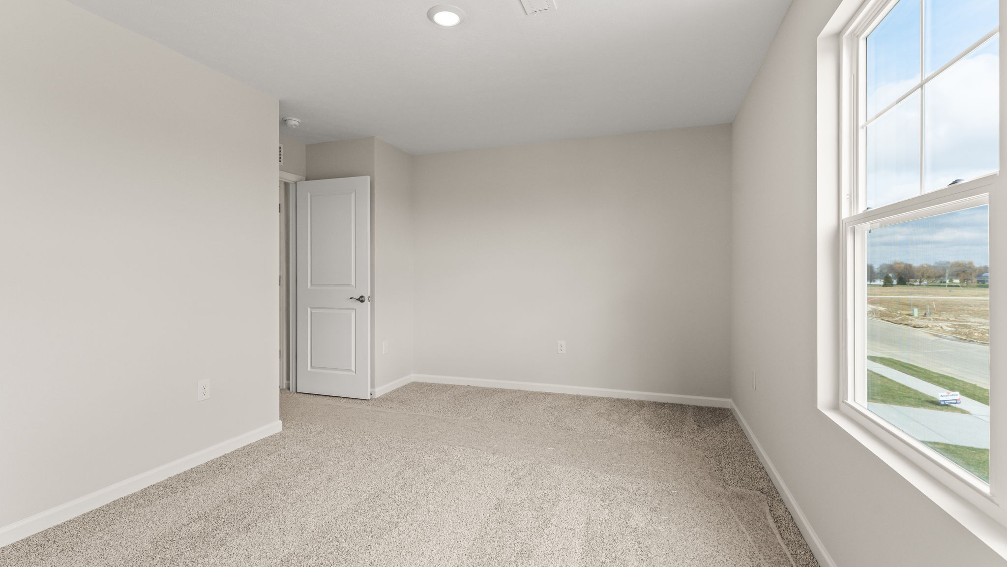 Carpeted bedroom with door to hallway.