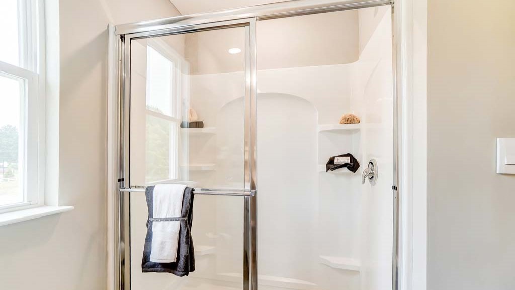 Primary bathroom with dual vanity sinks, large mirror, and view of the walk-in closet.