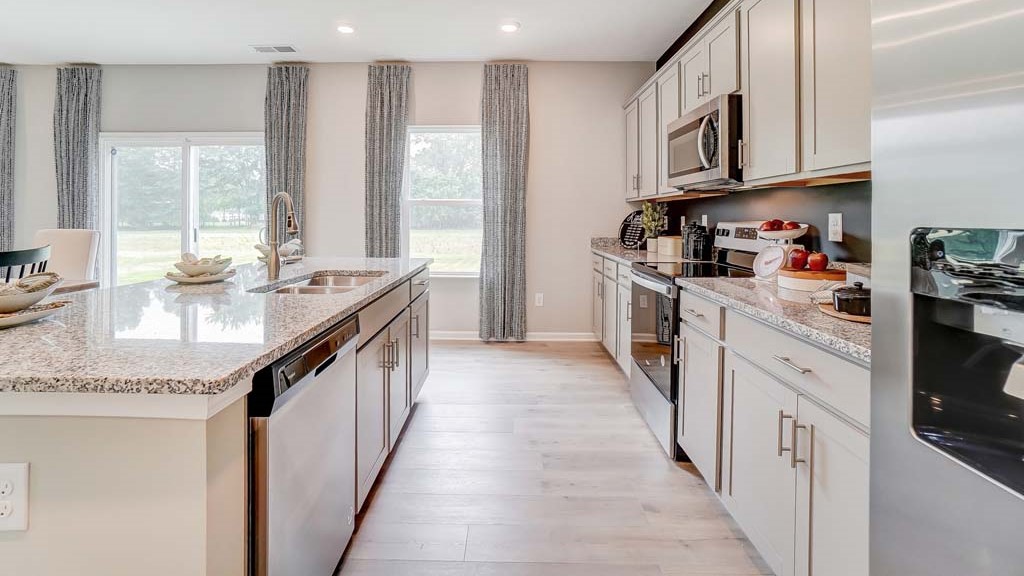 Shotgun view of the kitchen with granite countertops and stainless steel whirlpool appliances.