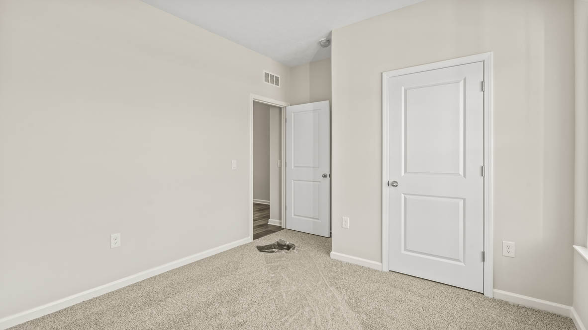 Bedroom from window perspective with hallway and closet in frame.