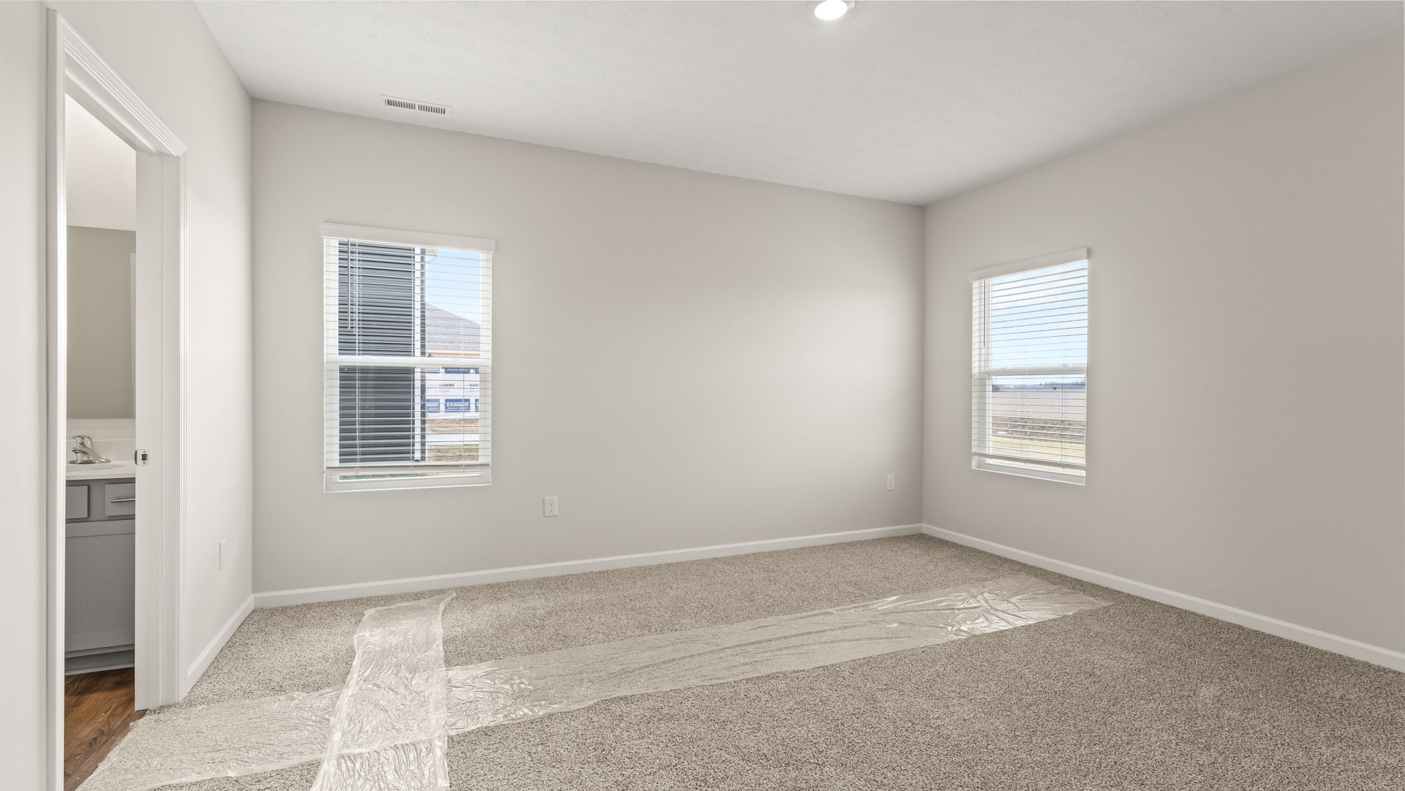 Primary bedroom with view into primary bathroom