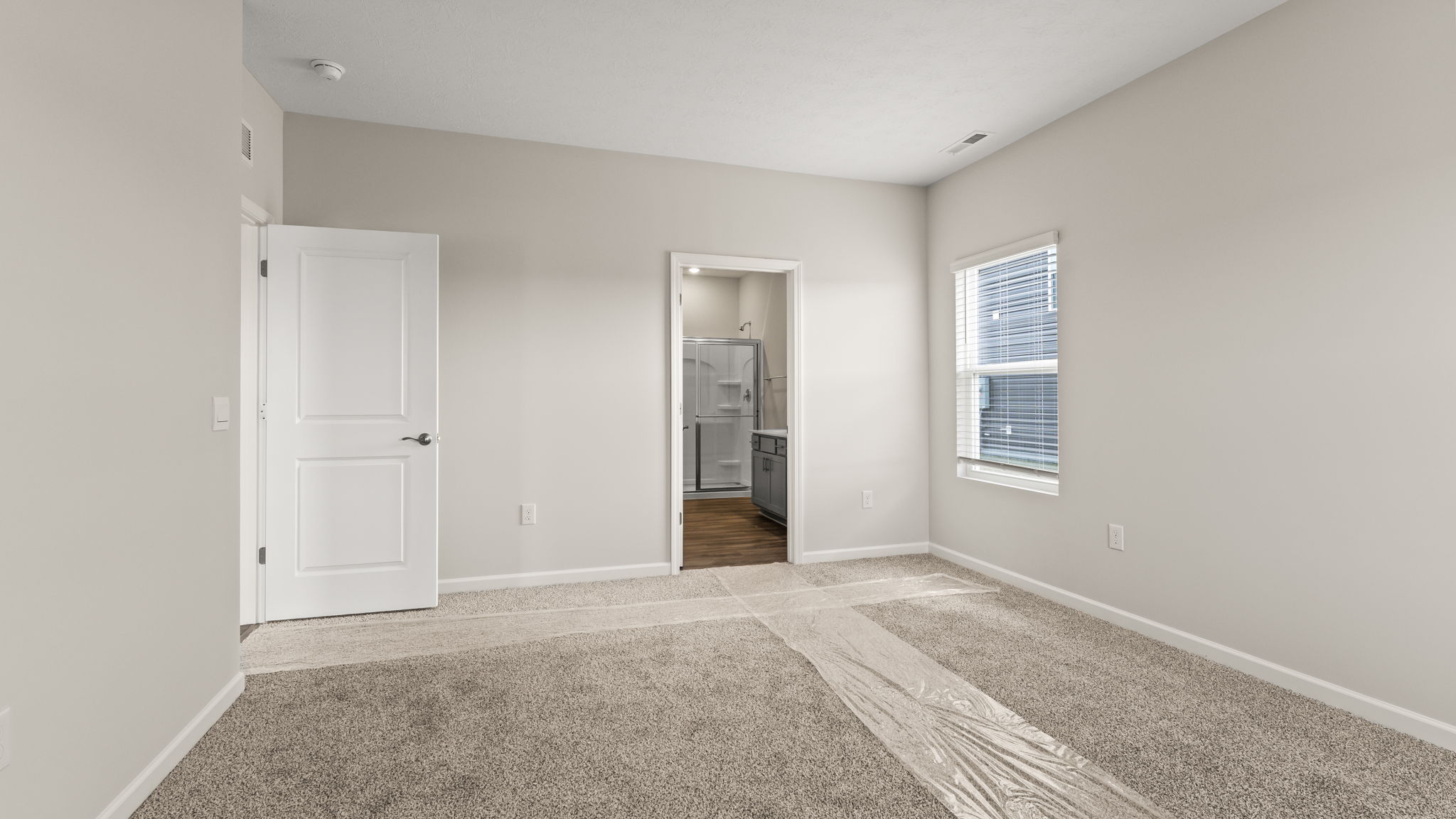 Primary bedroom looking into primary bathroom.