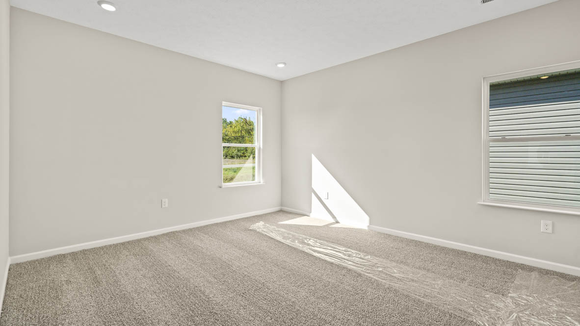 Primary bedroom with two windows.