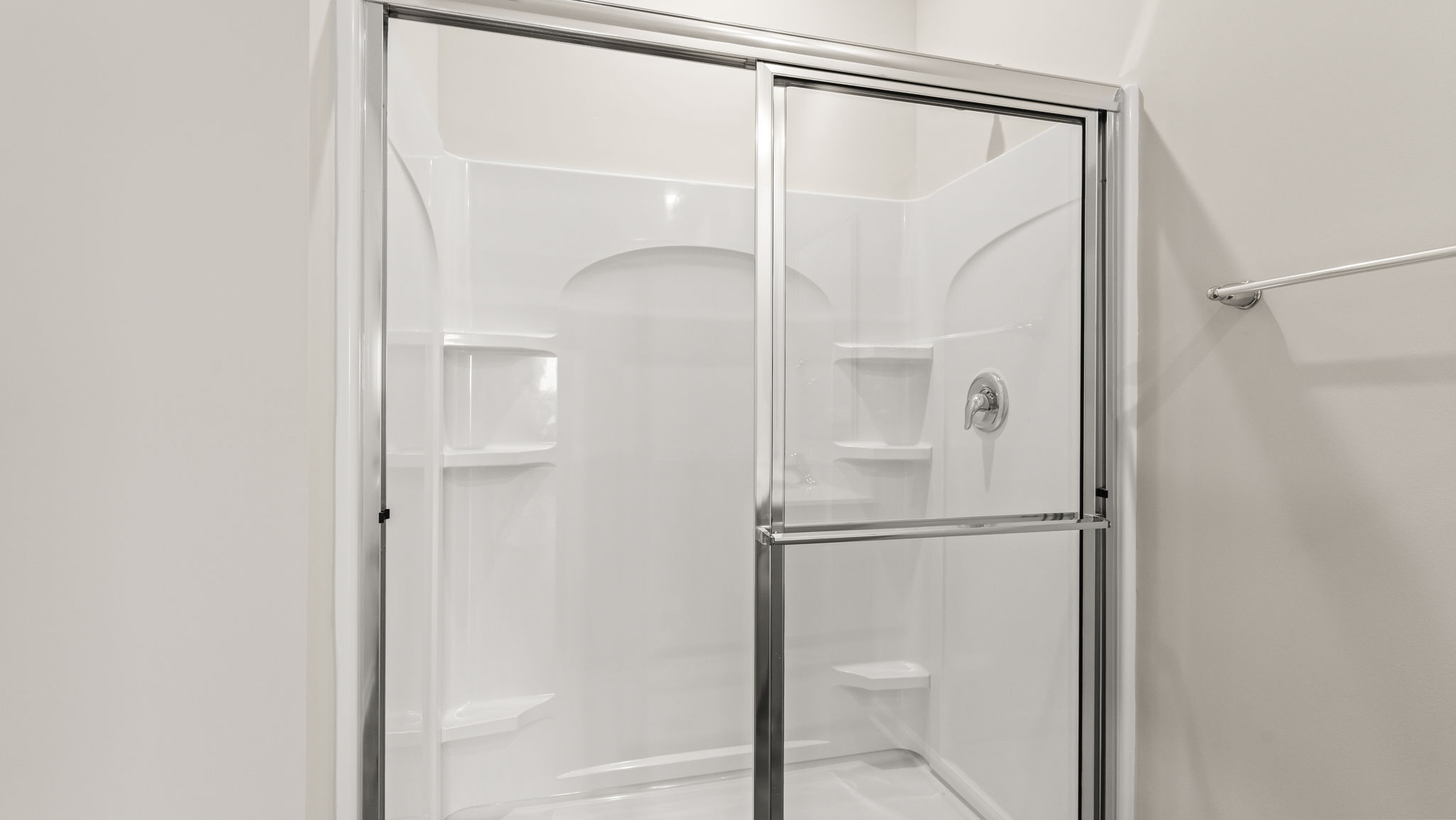 Closeup of walk-in shower with tiered shelving.