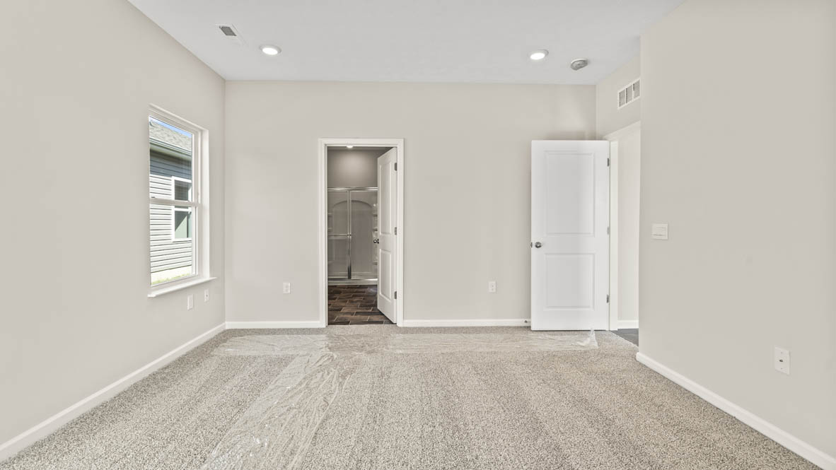 Primary bedroom looking into primary bathroom