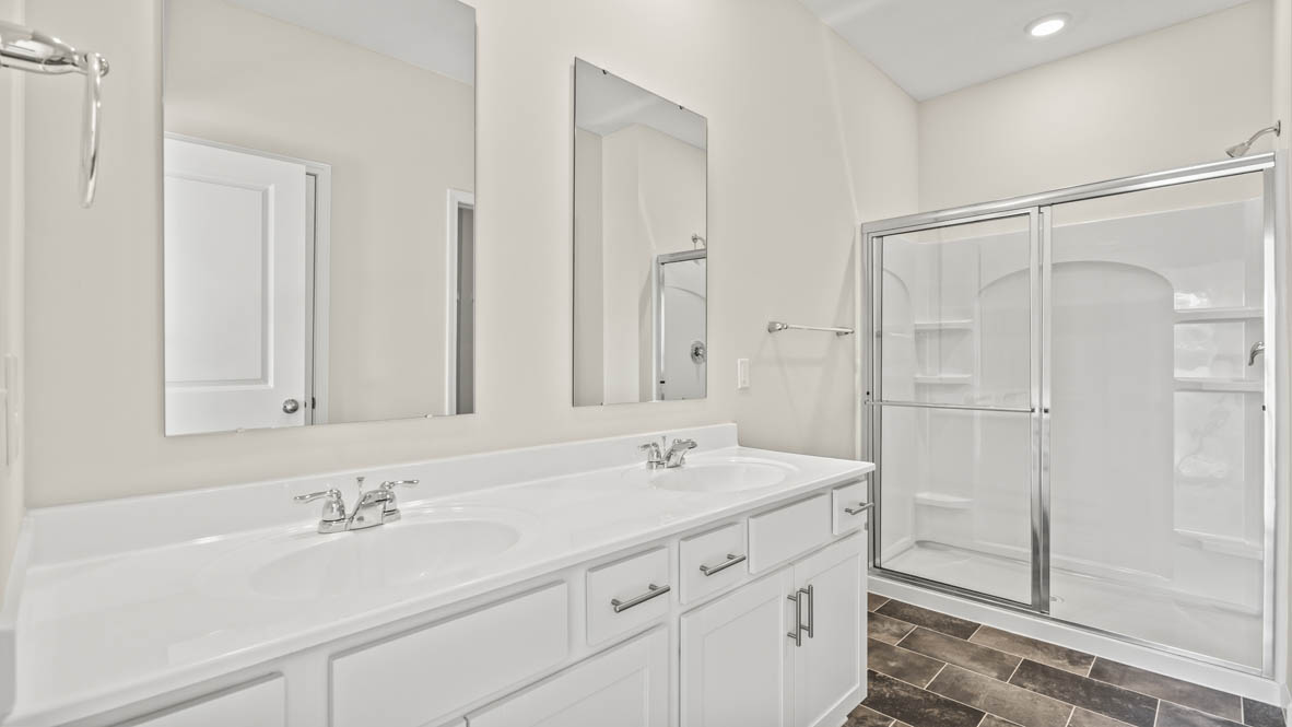Primary bathroom with double vanity and shower