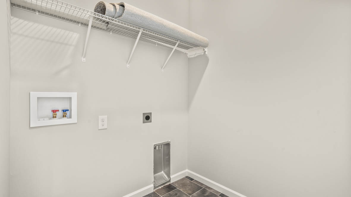 Laundry area with washer inlets and shelves.