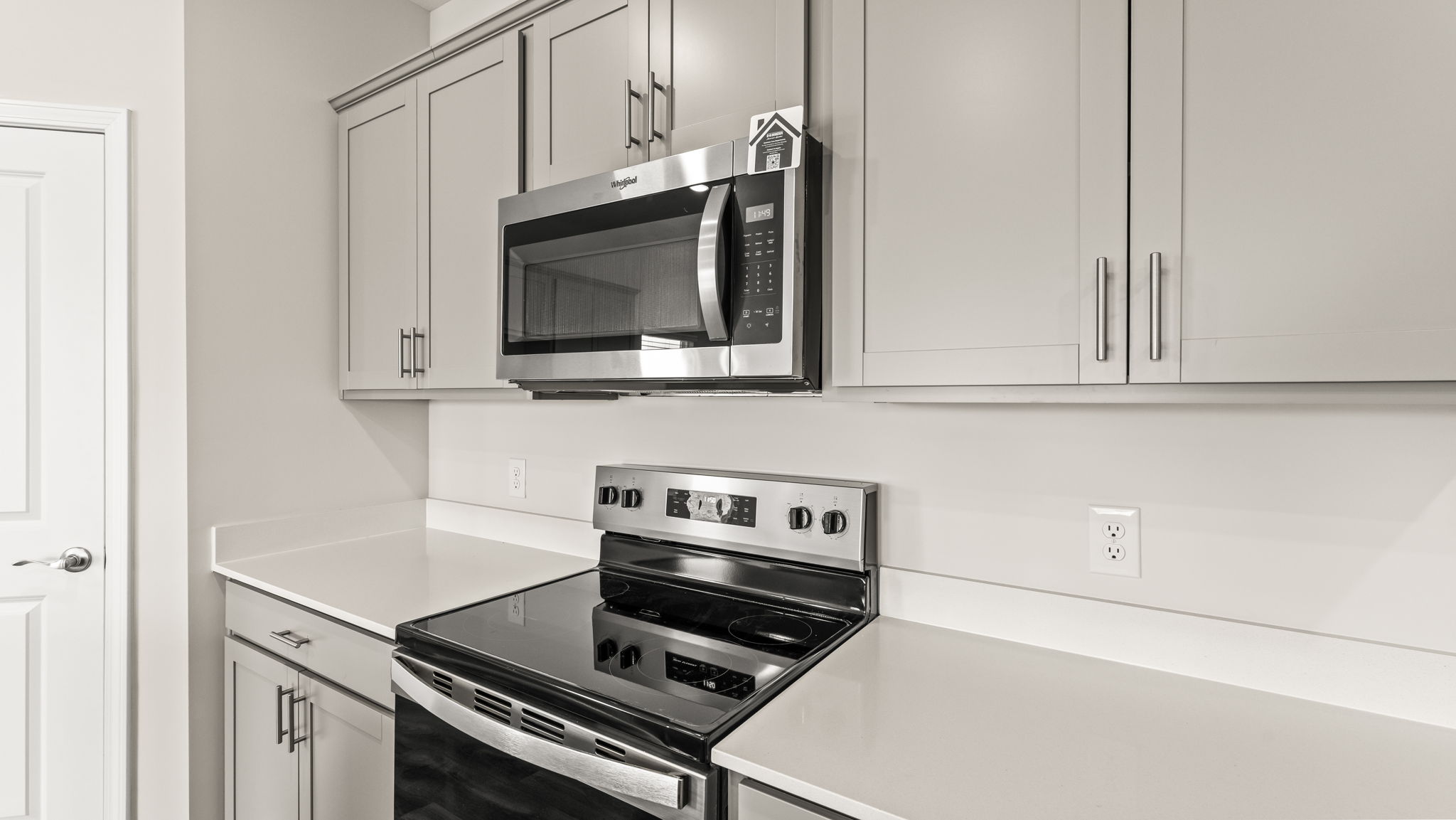 Closeup of oven range and microwave between cabinetry.