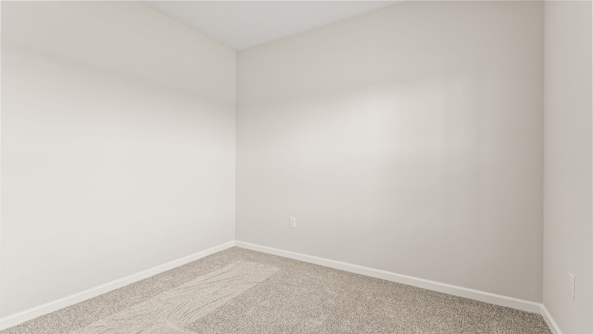 Carpeted bedroom with white walls.