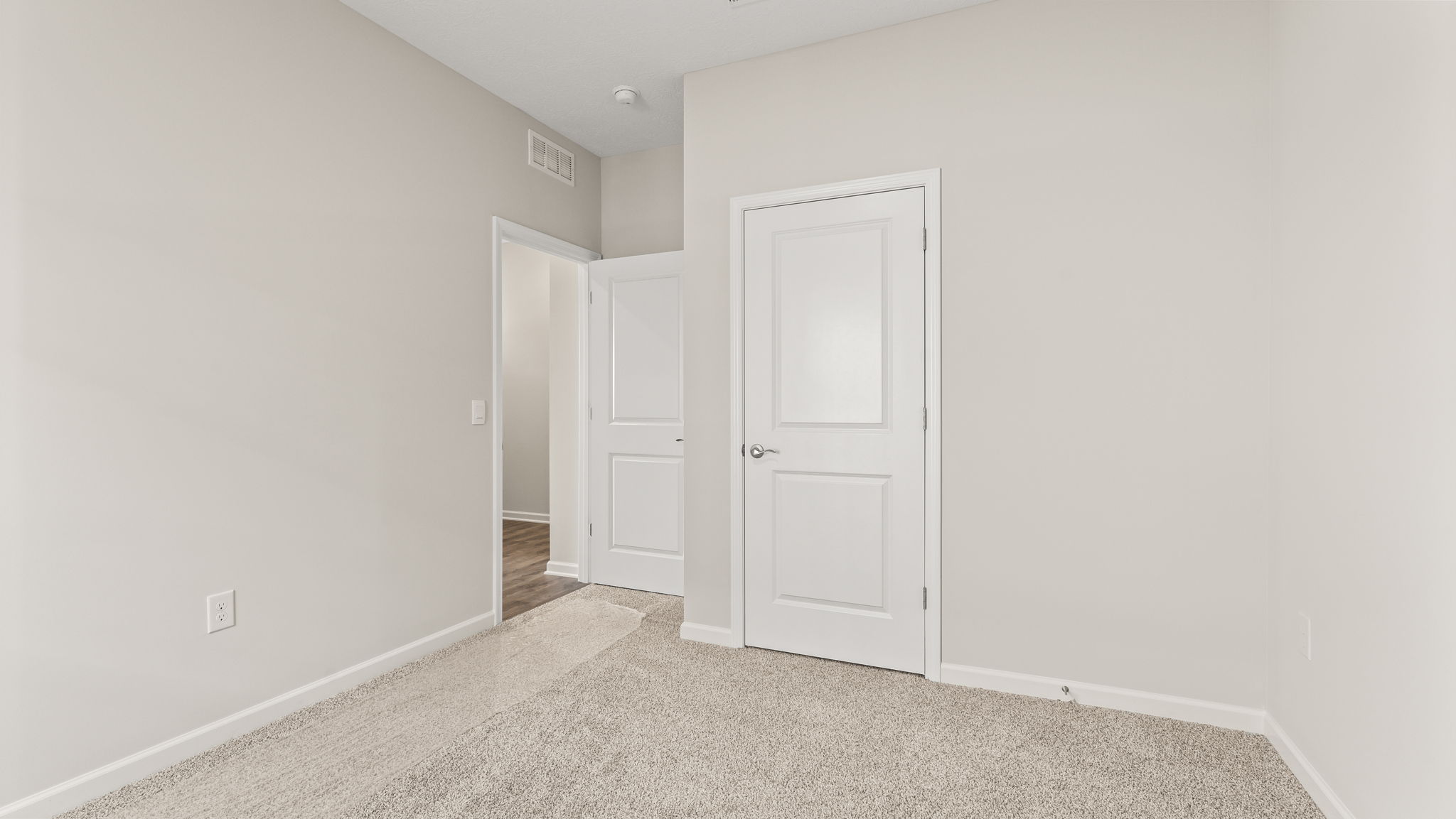 Carpeted bedroom with window and doorway