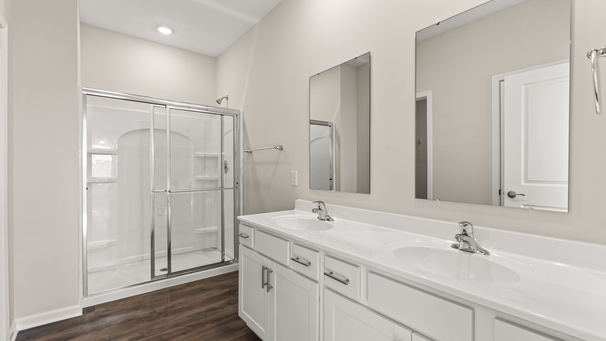 Dual-vanity sink with mirrors and walk-in shower.