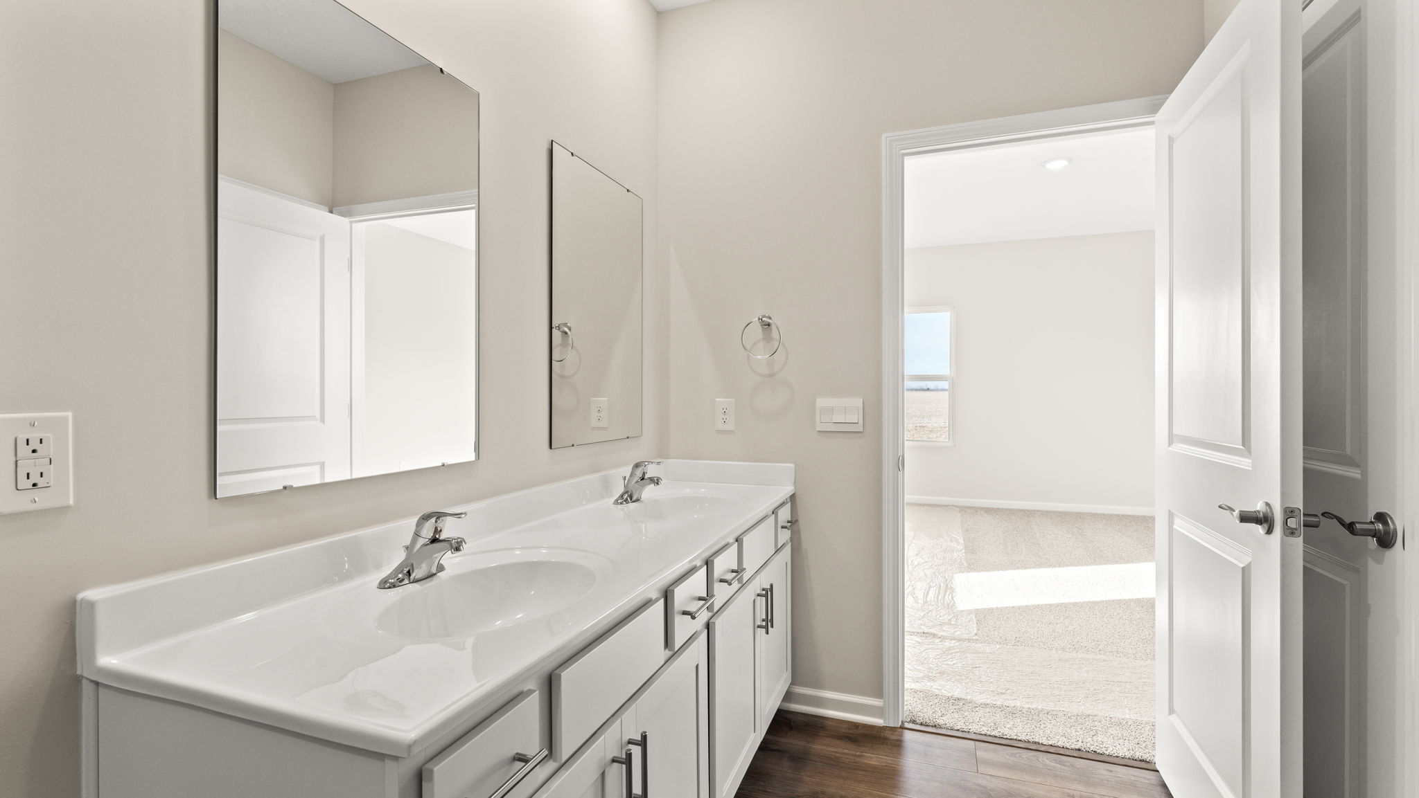 Closeup of vanity with primary bedroom in the back.