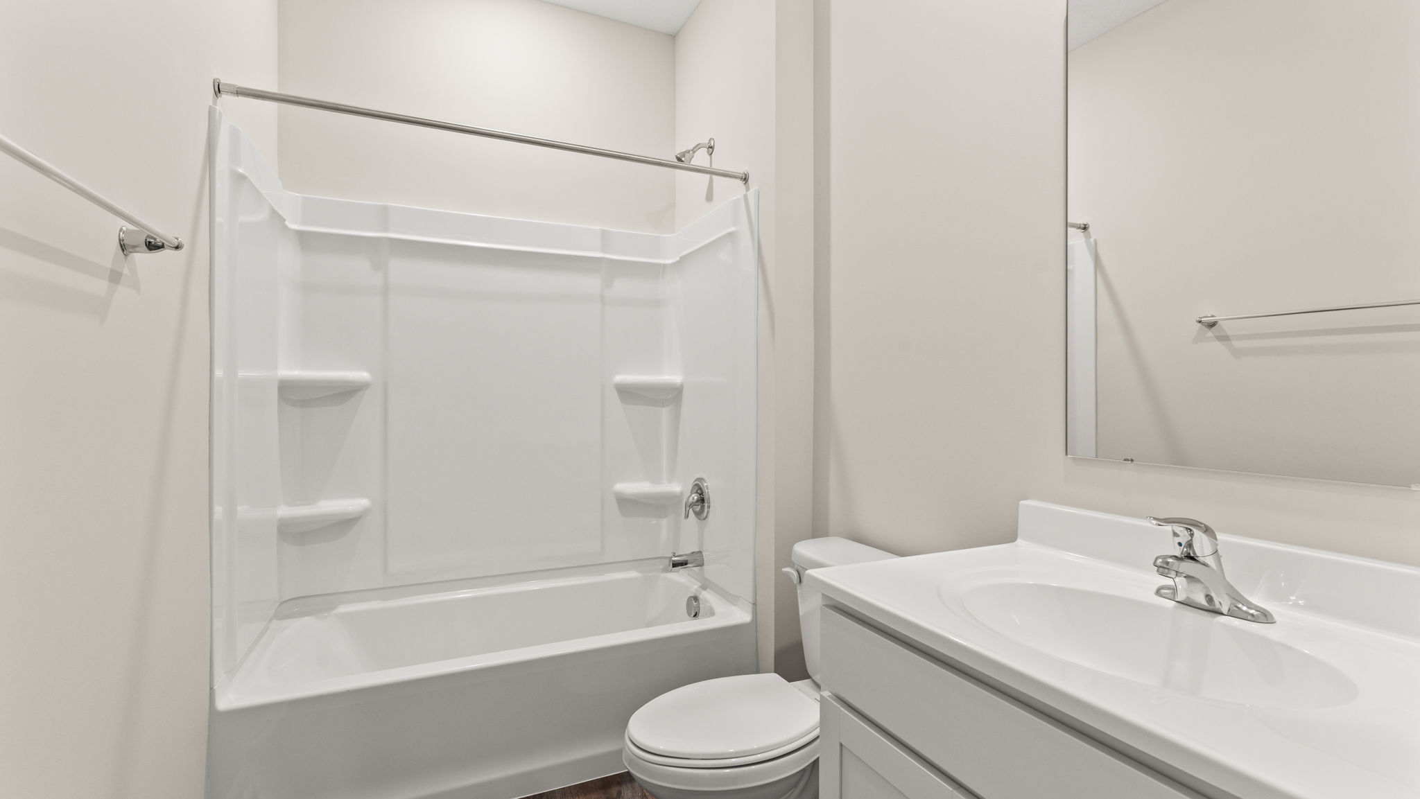 Bathroom with sink, toilet, and tub/shower combo with tiered shelving.