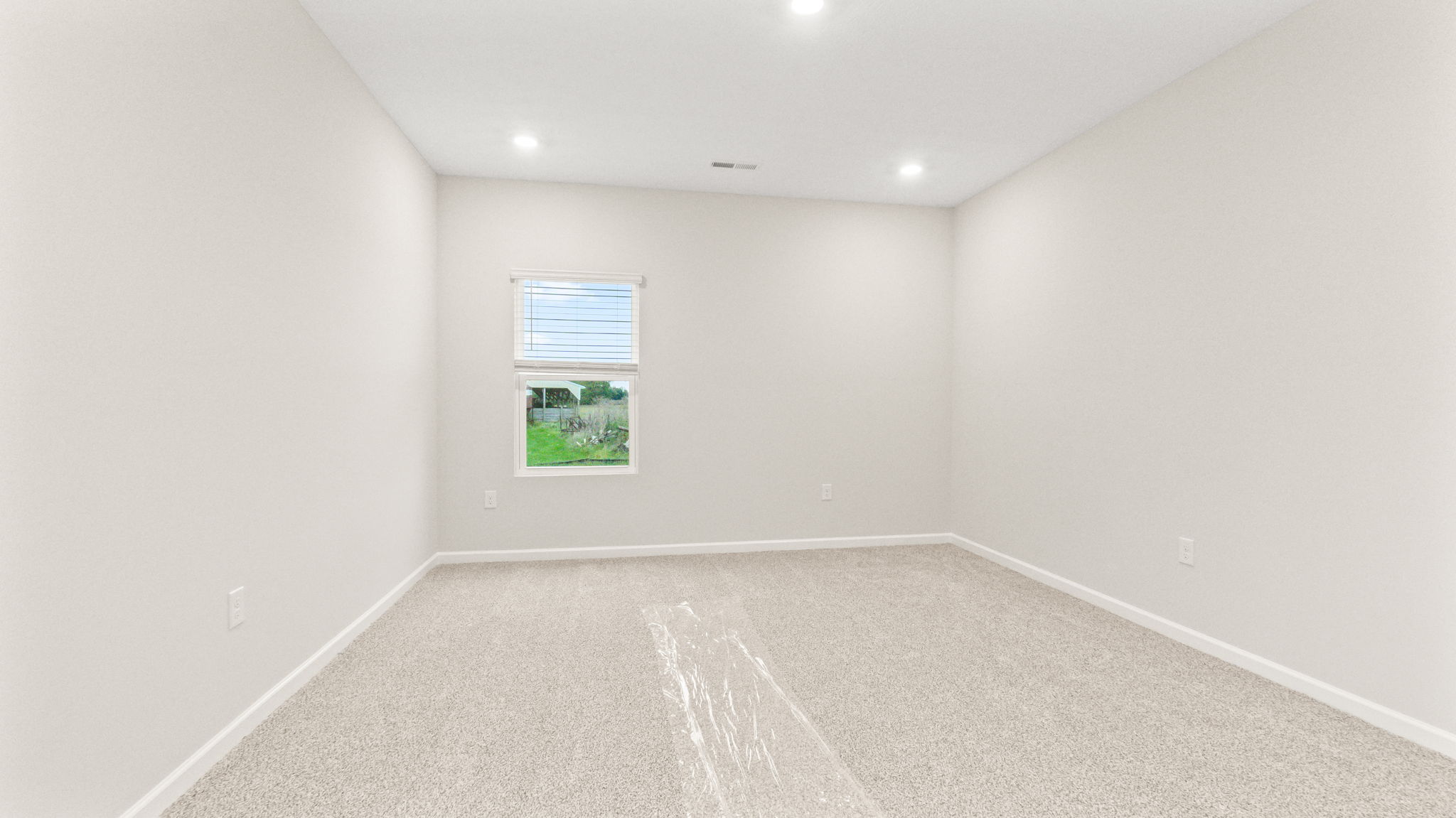 Carpeted primary bedroom with window