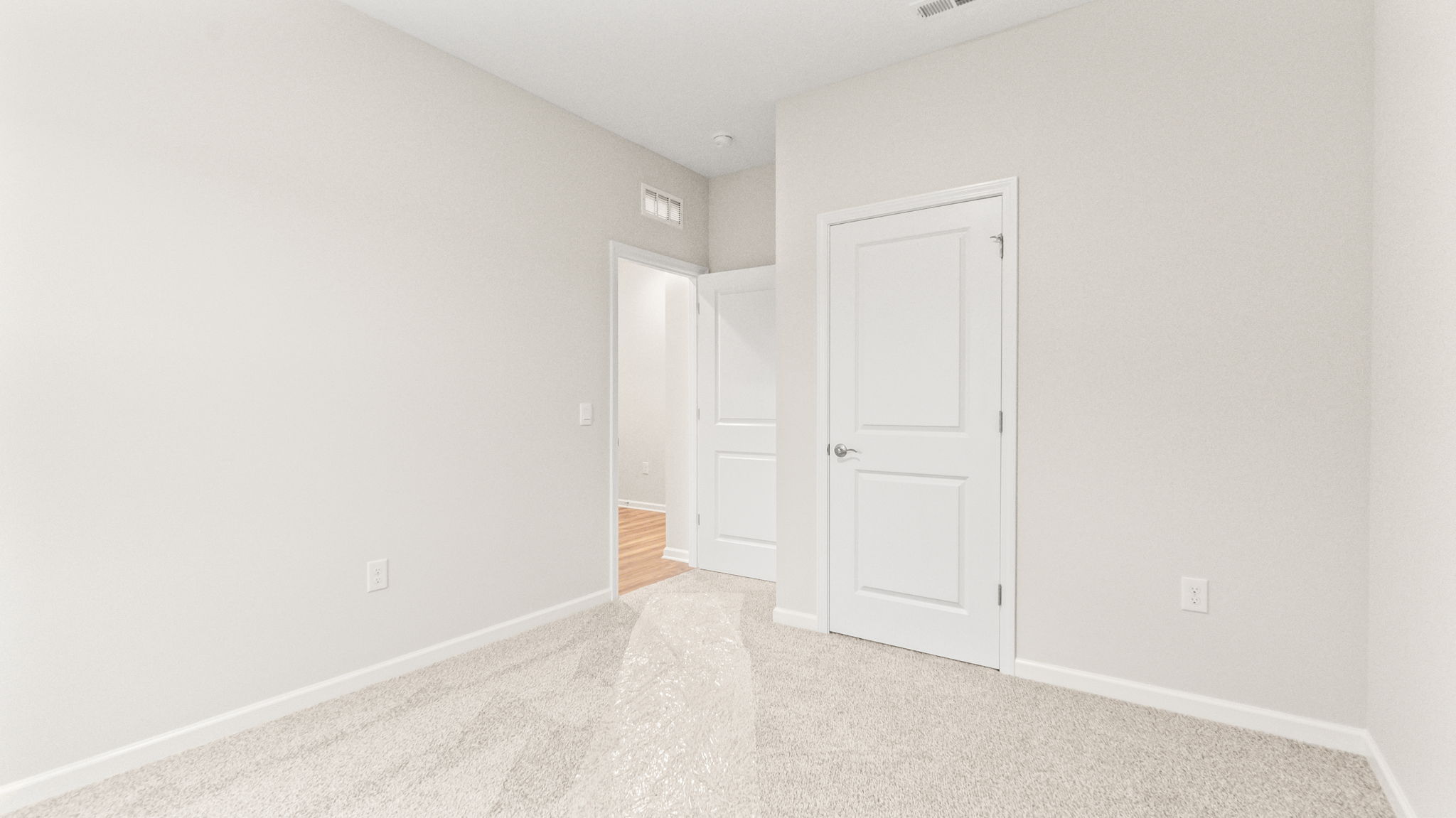 carpeted bedroom with view of hallway