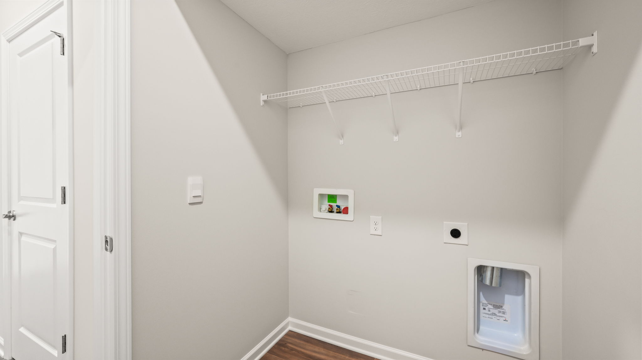 Laundry area with wire rack shelving and washer/dryer inlets