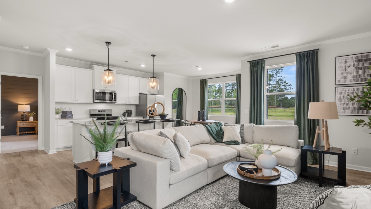 Open-concept living, dining, and kitchen area with fresh airy decorations.