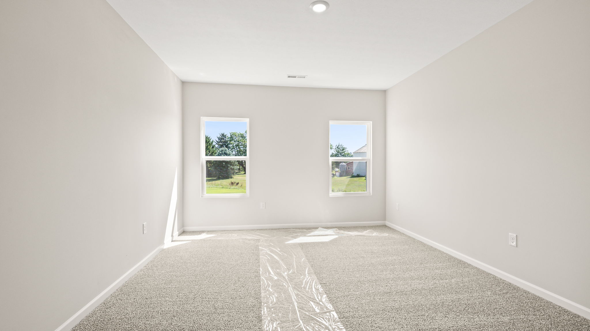 Carpeted primary bedroom with two windows