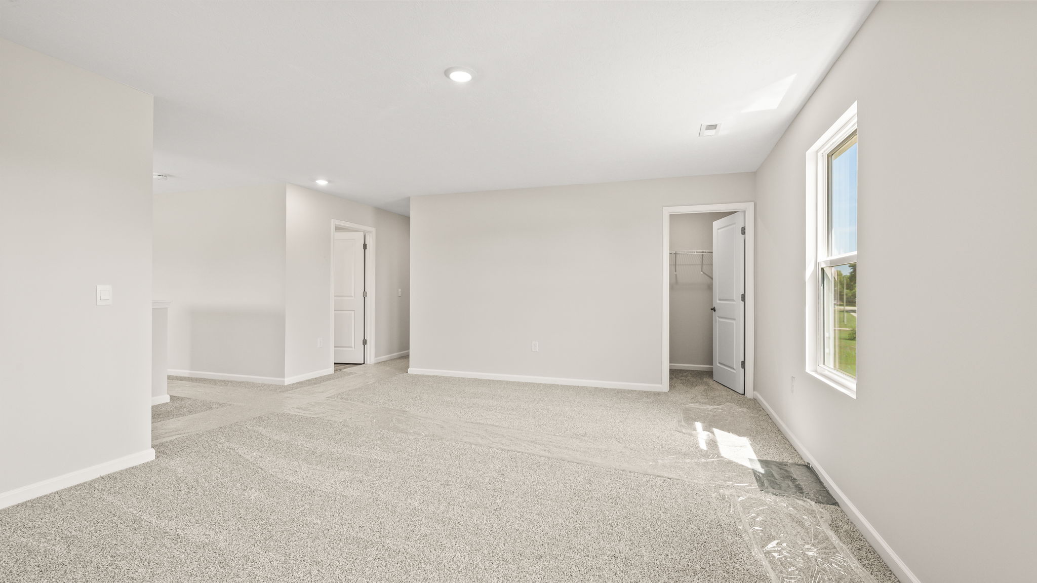 Wide angle image of carpeted loft with two windows