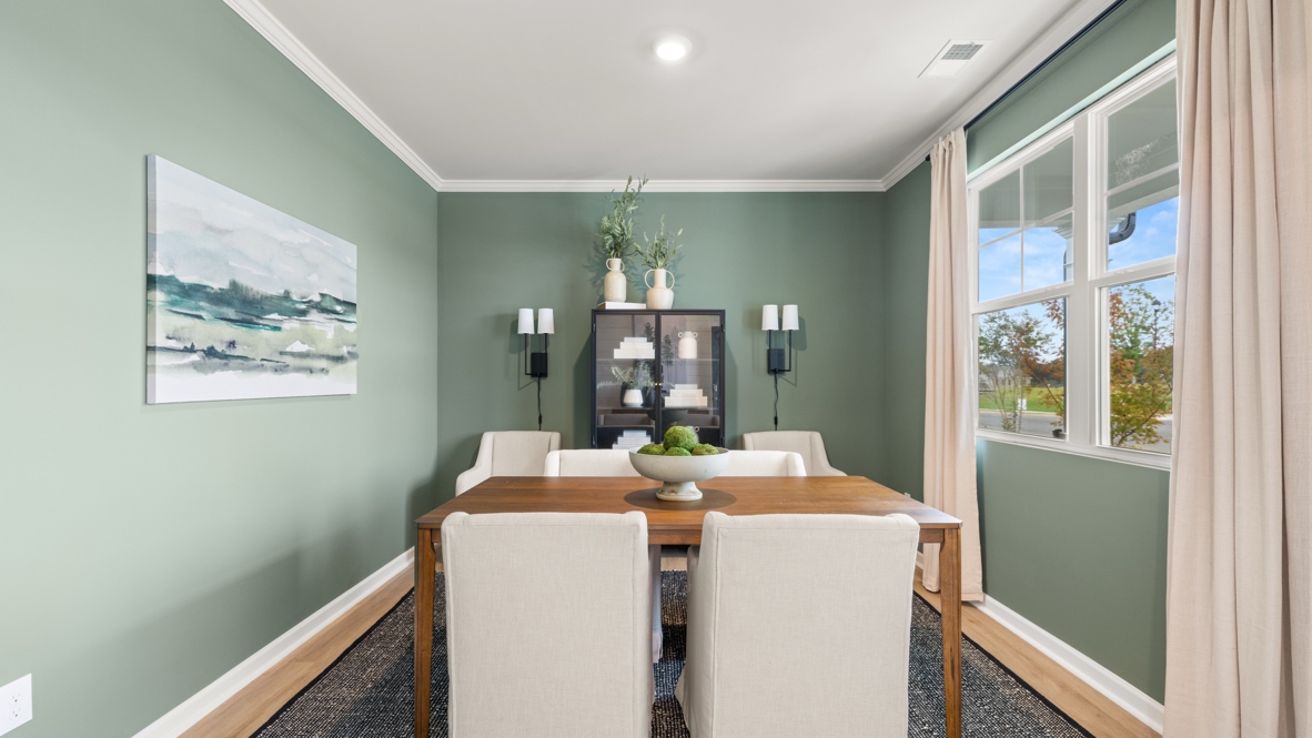 Flex room arranged with green walls, brown table, and white chairs