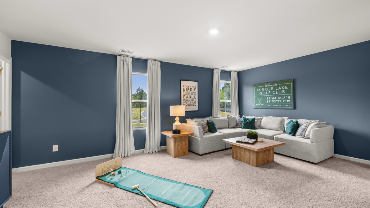 Loft area arranged as a second family room with miniature golf course and golf club picture on wall