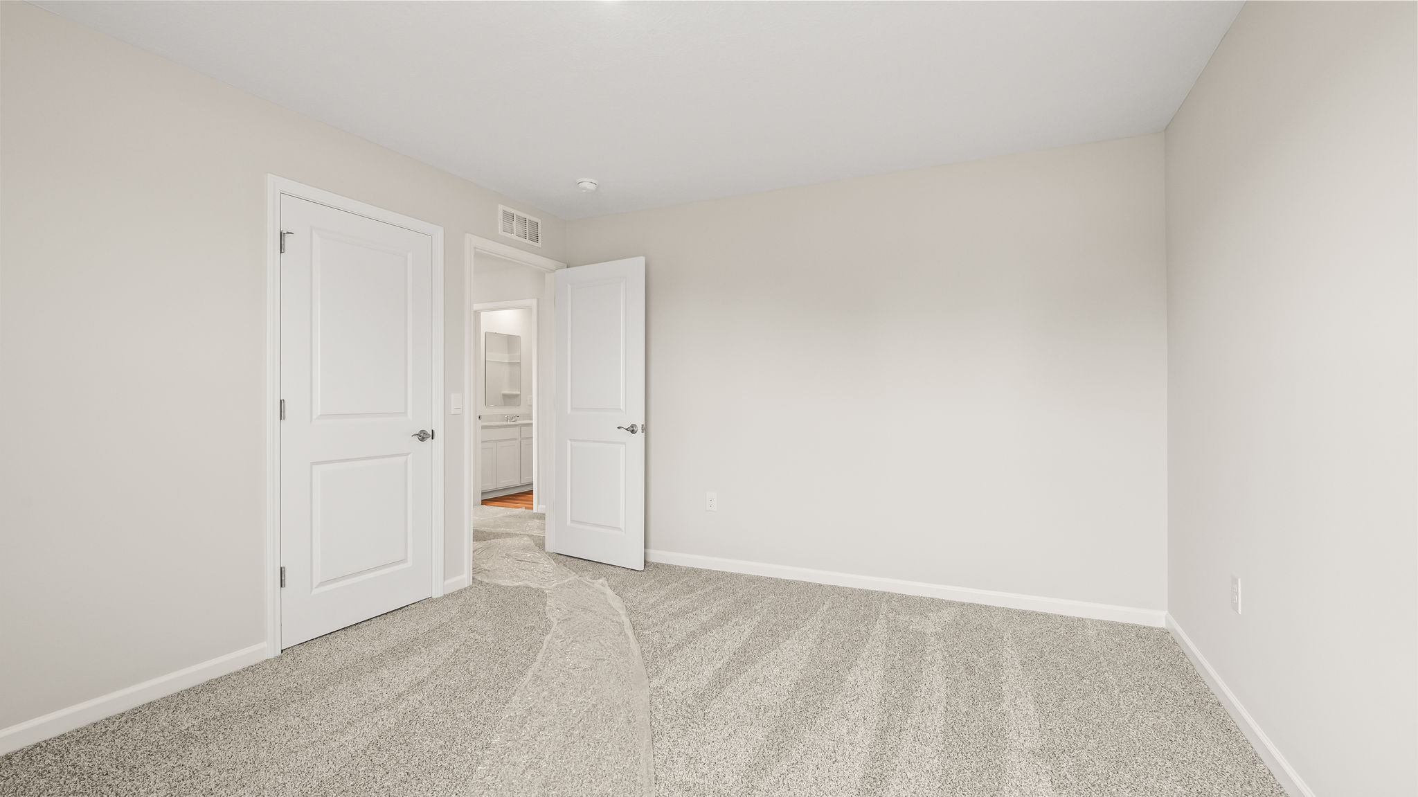 Carpeted bedroom with door to hallway