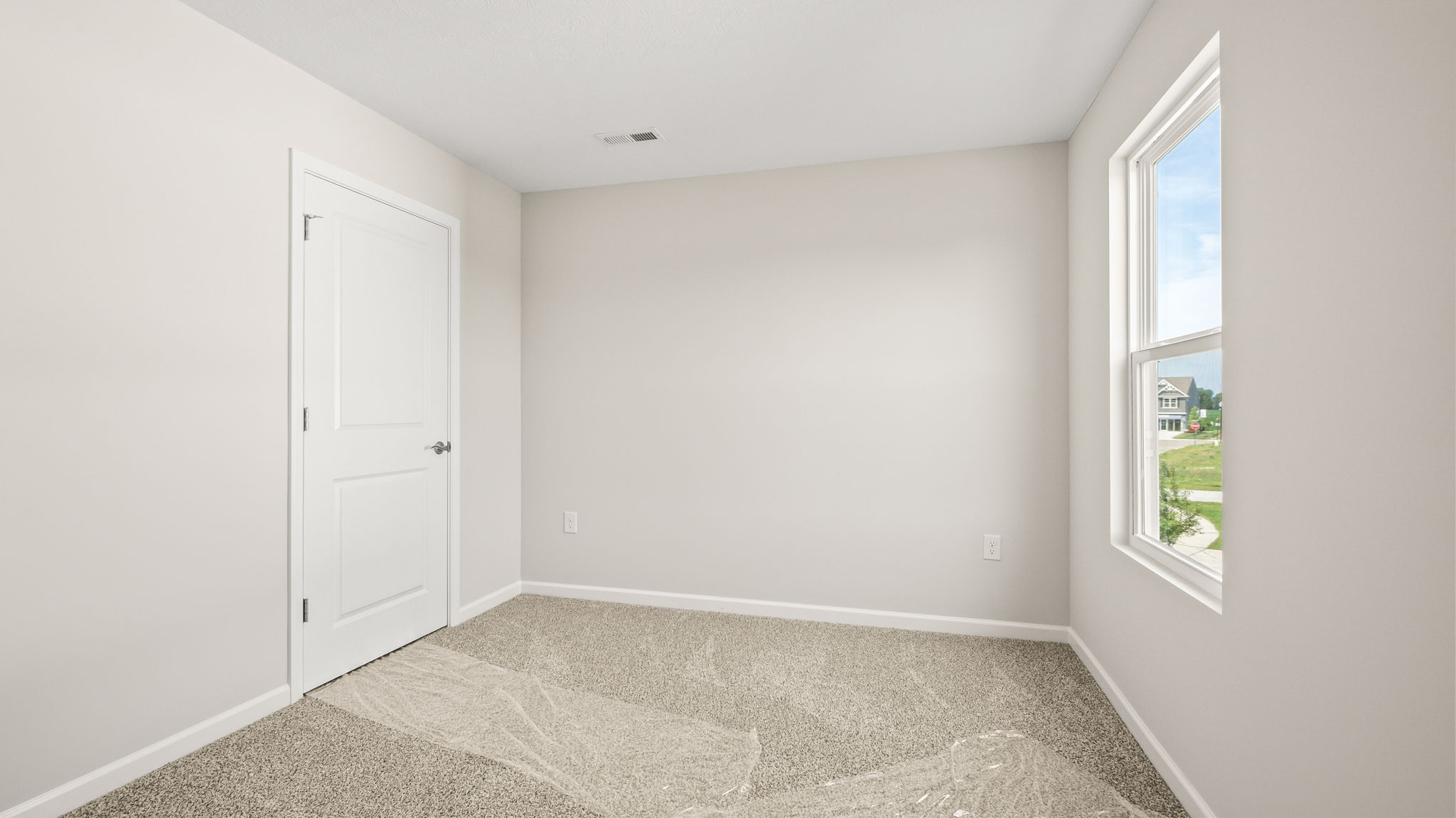 Carpeted bedroom with window and closet