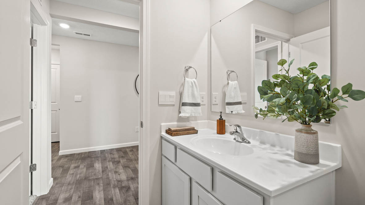 Shared bathroom with sink and view of foyer.
