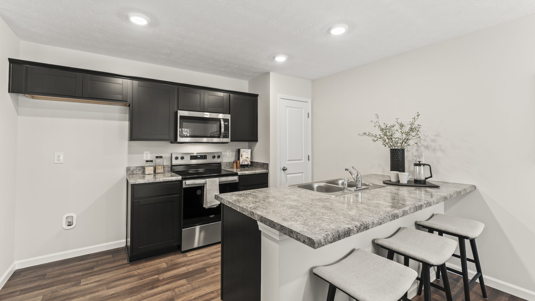 Functional kitchen with sink, multi-prep areas, cabinets, pantry access, new appliance suite, and outdoor connection