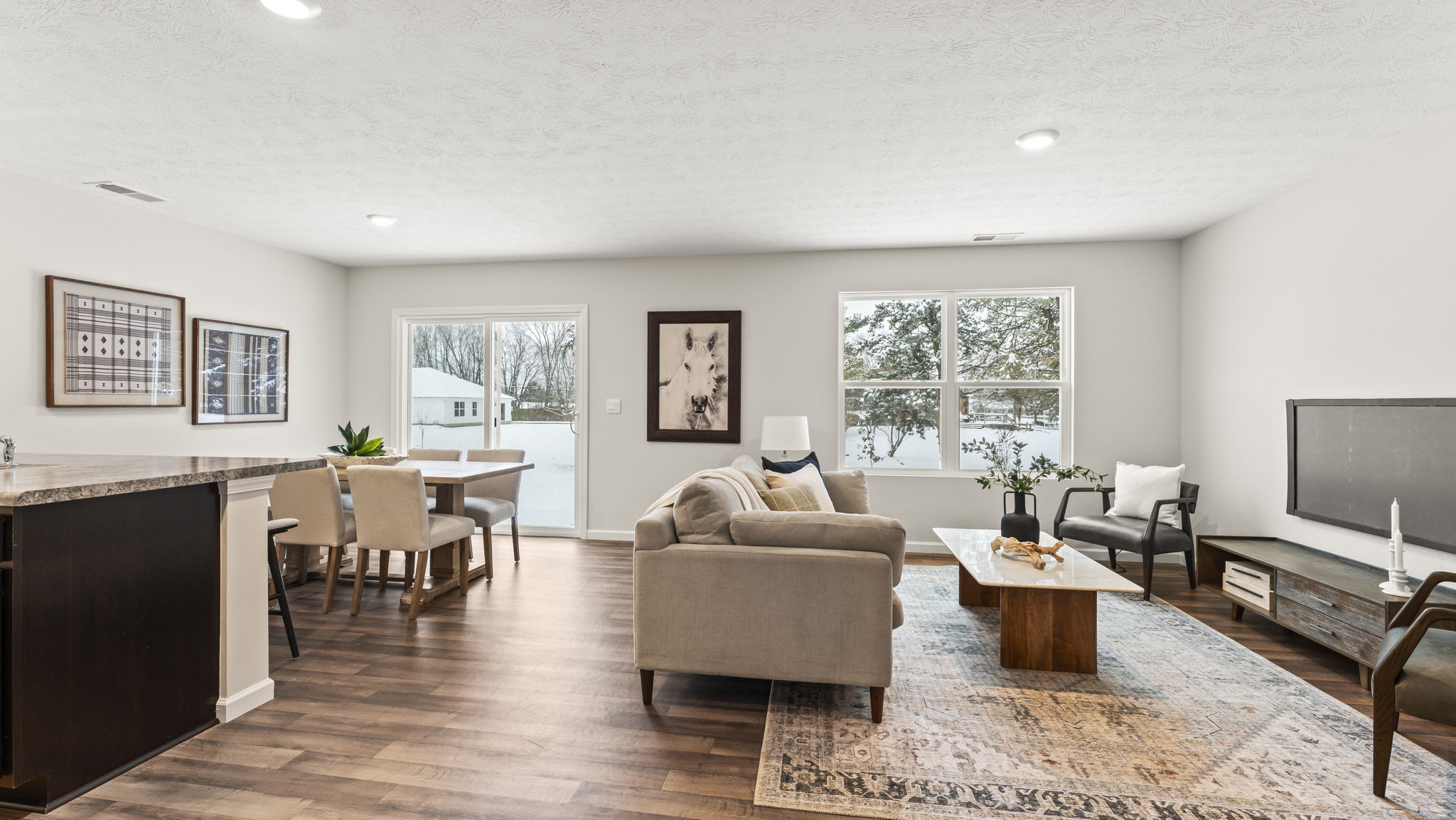 View from kitchen hall into dining and living areas with backyard and patio access