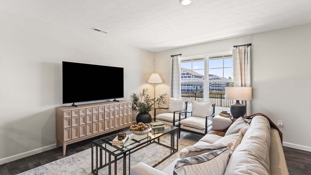 Living room with modern decoration in an earthy pattern flatscreen tv, lamps, couch, and chairs.