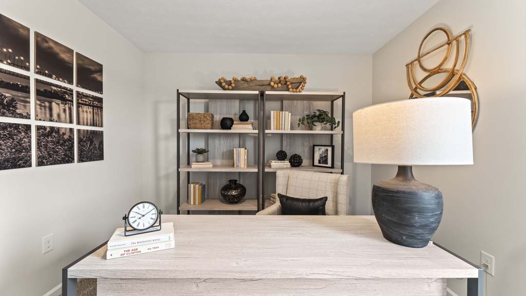 Flex room arranged as an office with brown and black pottery, baskets, and wooden table
