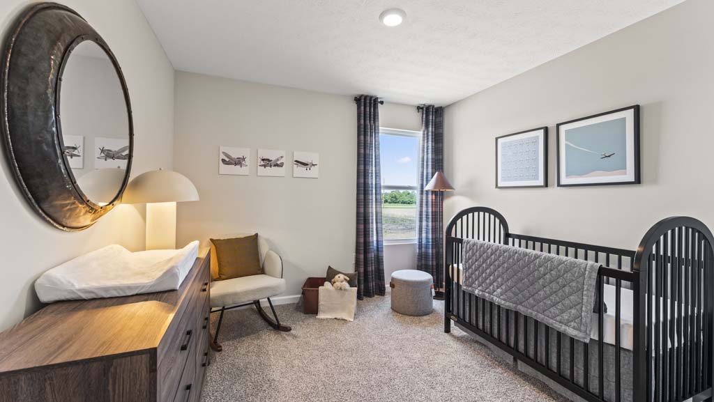 Bedroom arranged as a nursery with airplane-theme modern art, crib, and carpet