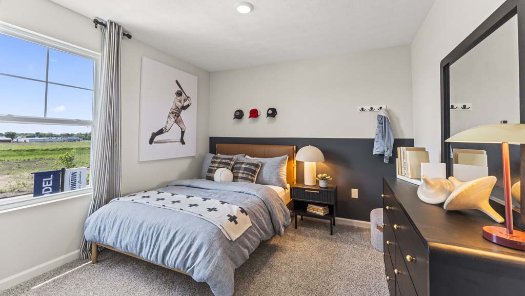 Spacious bedroom with baseball-themed decoration including pillows, drawings, and baseball caps