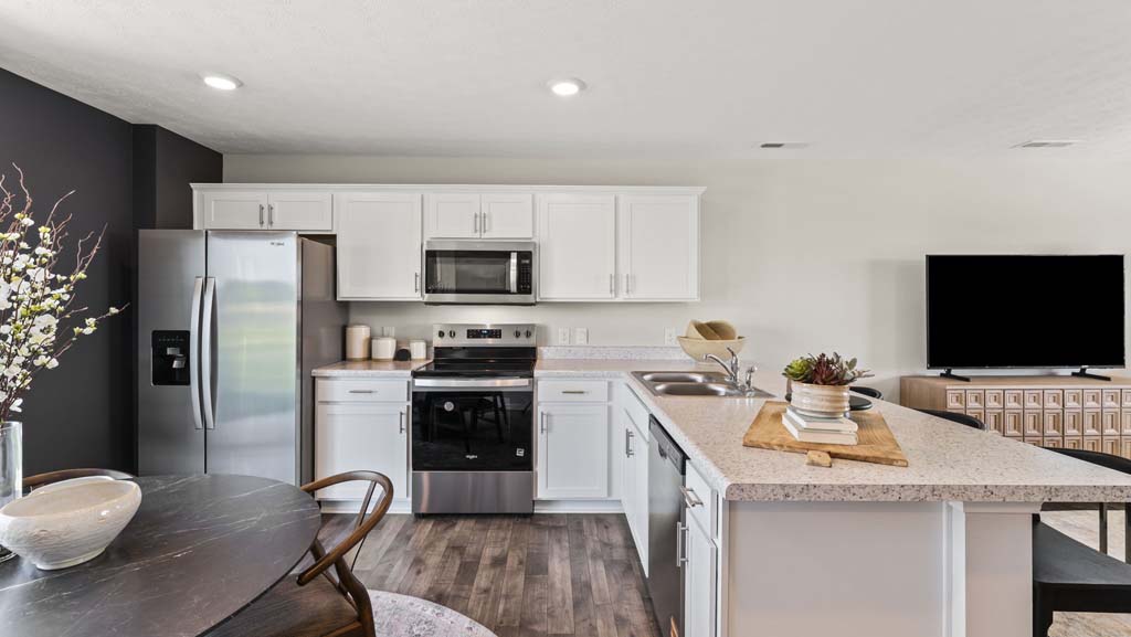Side view of kitchen with laminate counter, stainless steel appliances, white cabinetry, and dish washer