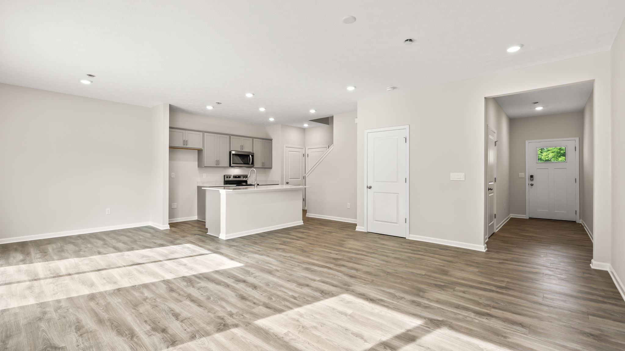 wide image of great room with kitchen as the focus