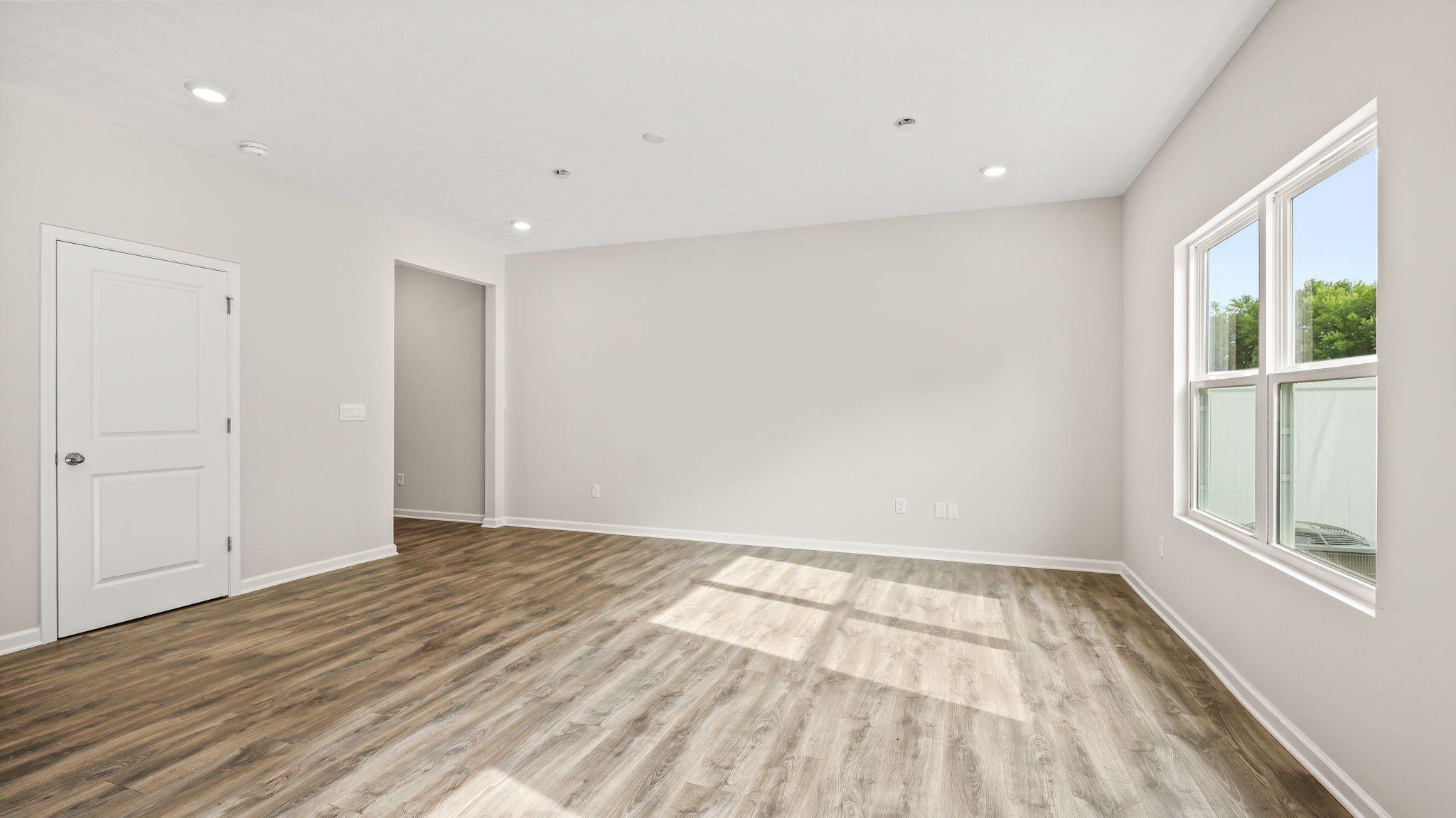 Living room area with window and door to hallway