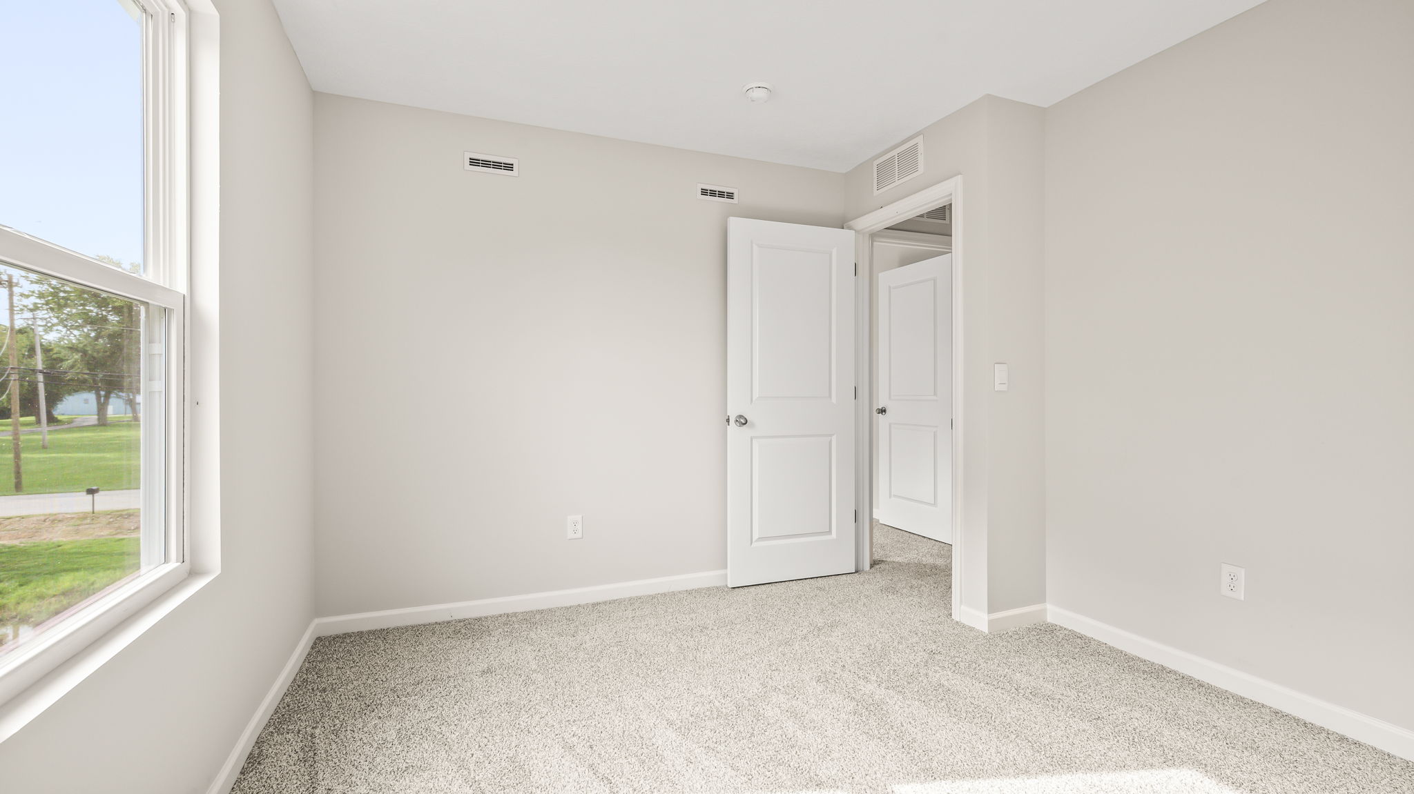 Carpeted bedroom with door to hallway