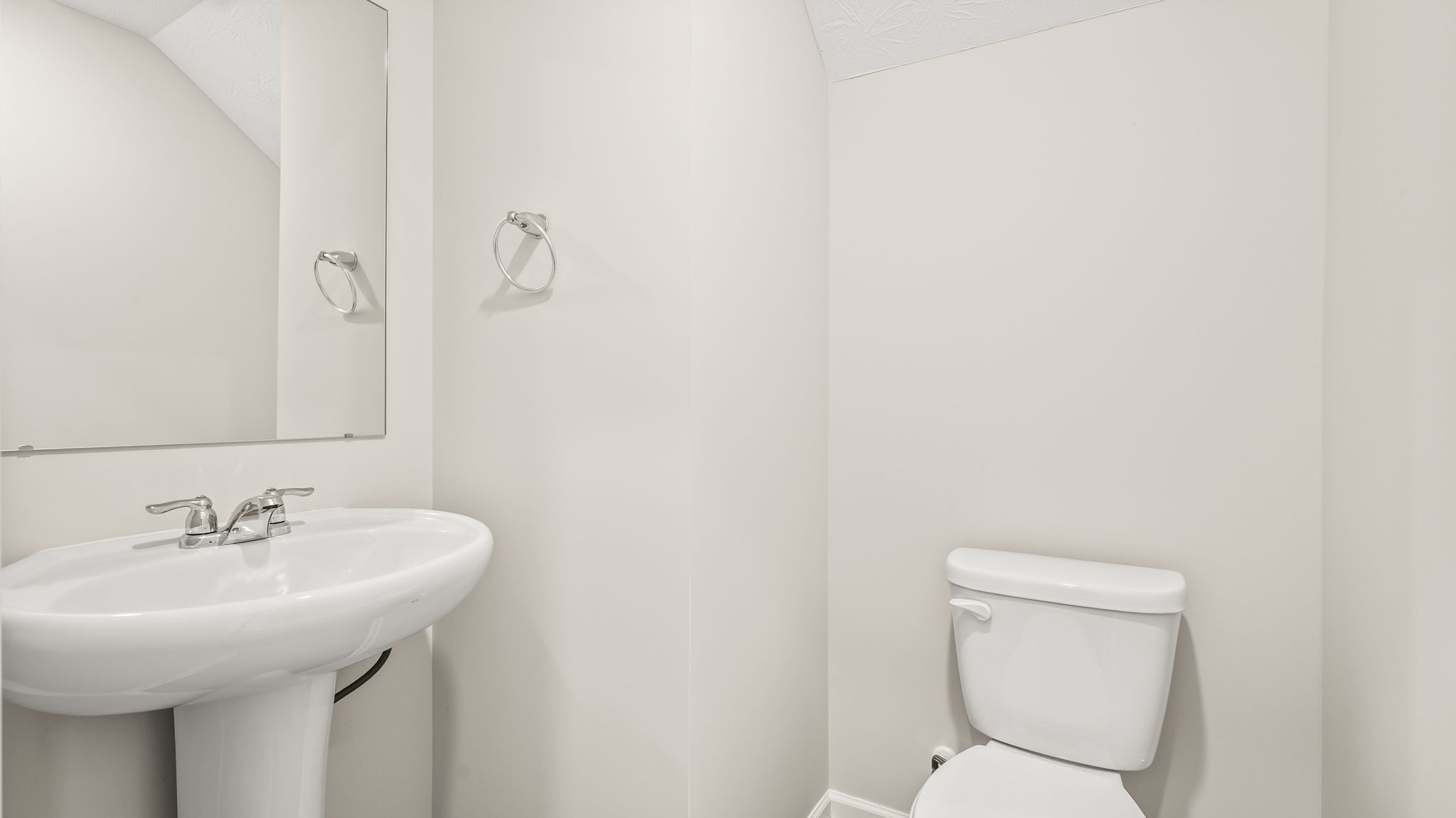Powder room with sink, mirror, and toilet