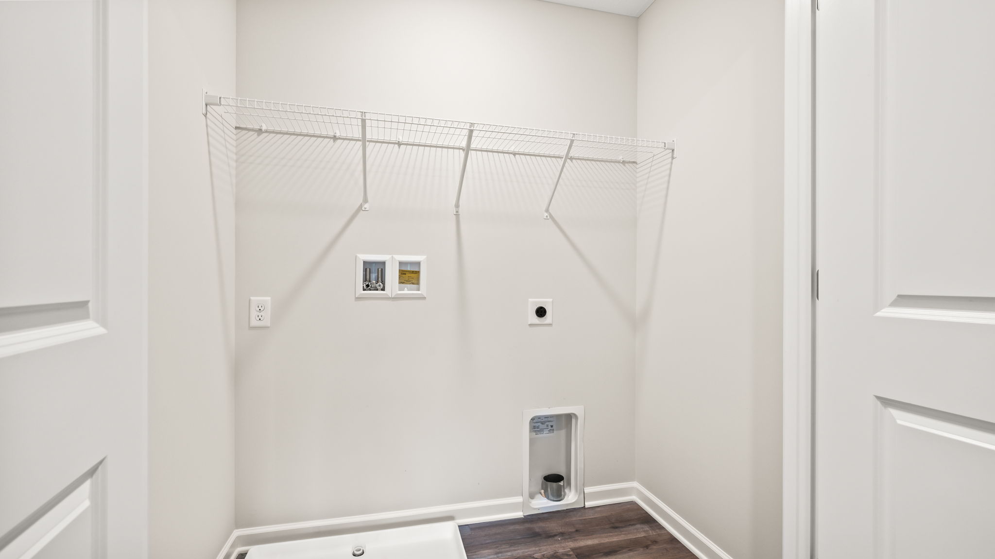 Laundry area with washer/dryer inlets and wire rack shelving