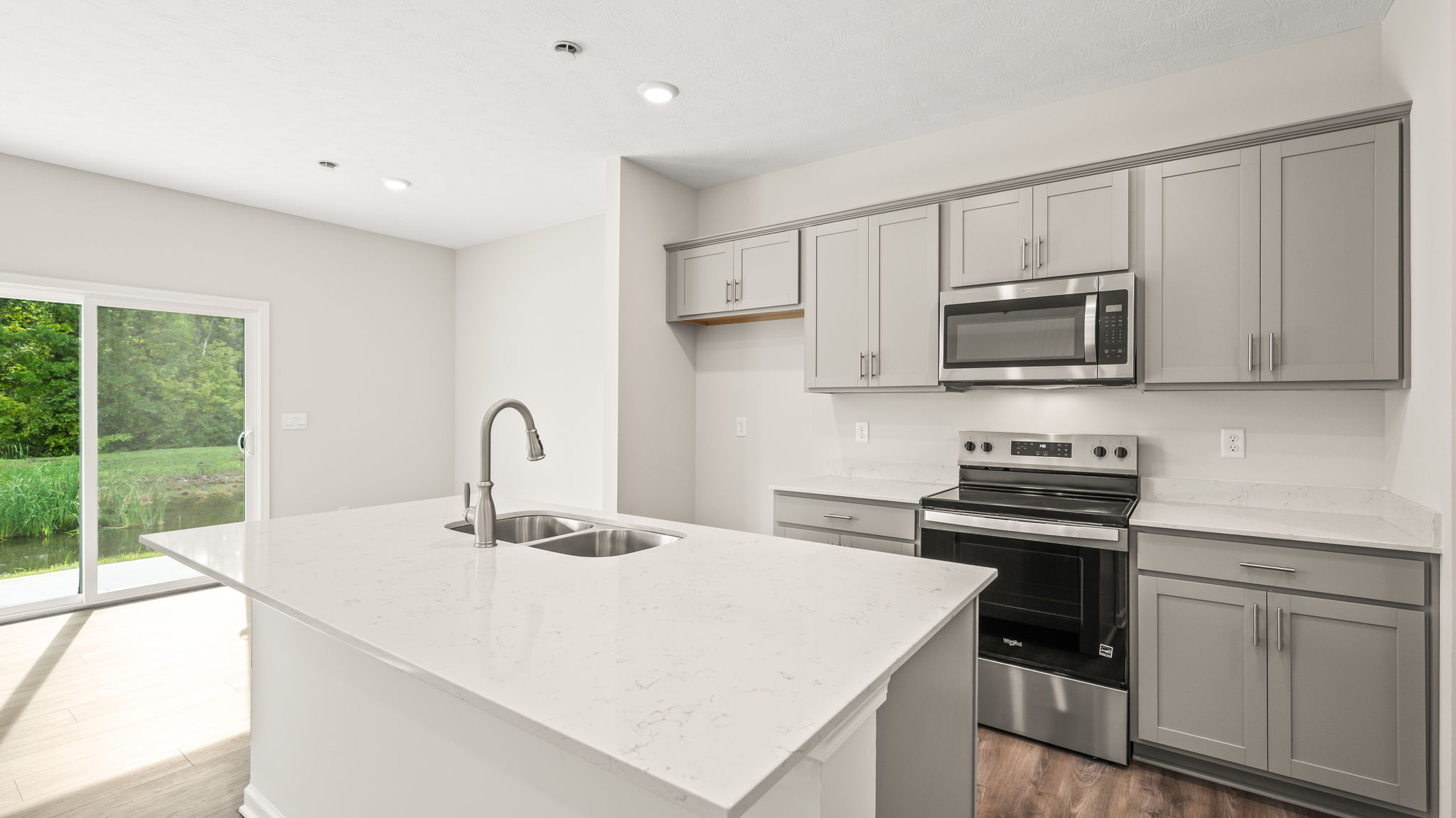 three-quarter view of kitchen with white countertops and gray cabinetry