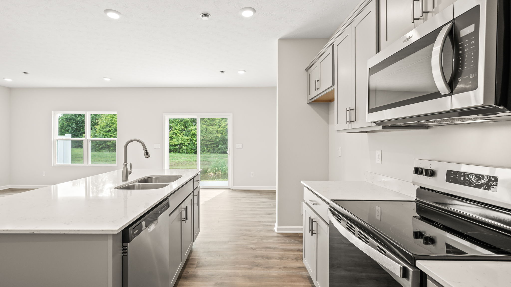 Side view of kitchen with island on the left and oven range/microwave on right